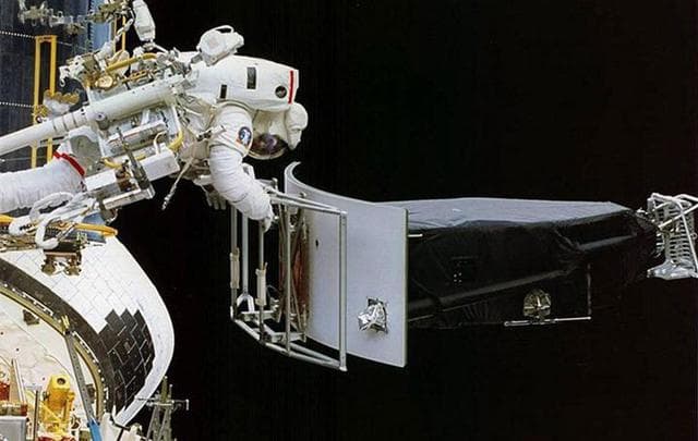 Astronauts performing repairs on the Hubble Space Telescope during a servicing mission