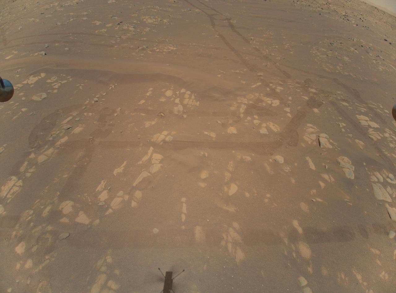 Shadow of the Ingenuity helicopter cast on the Martian surface during flight