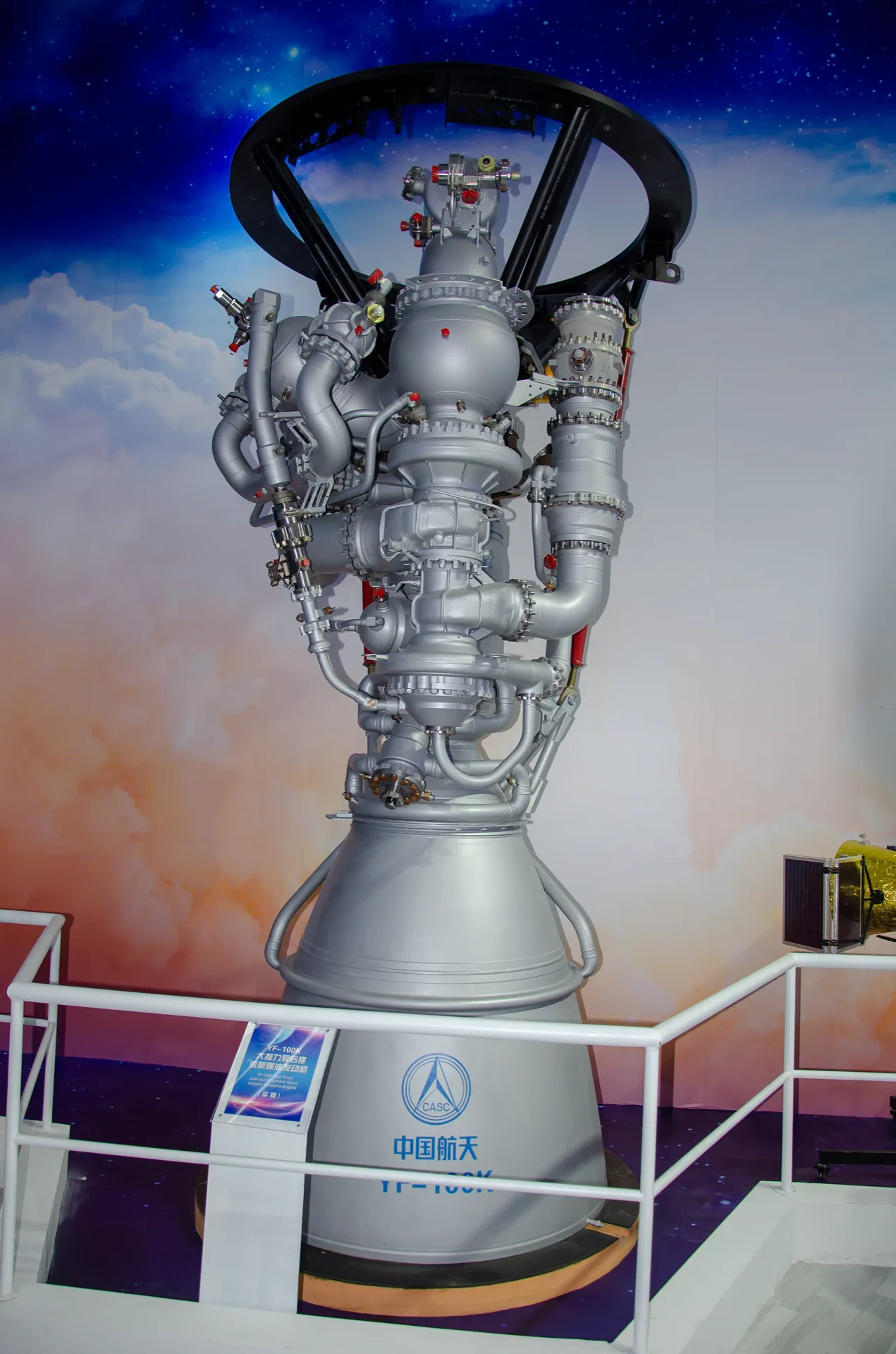 A YF-100K liquid oxygen and kerosene rocket engine displayed at an exhibition, marked with the CASC logo