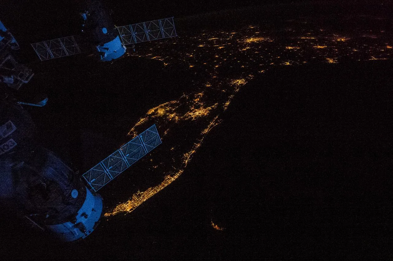 City lights at night from space — GPS underpins modern urban logistics and infrastructure