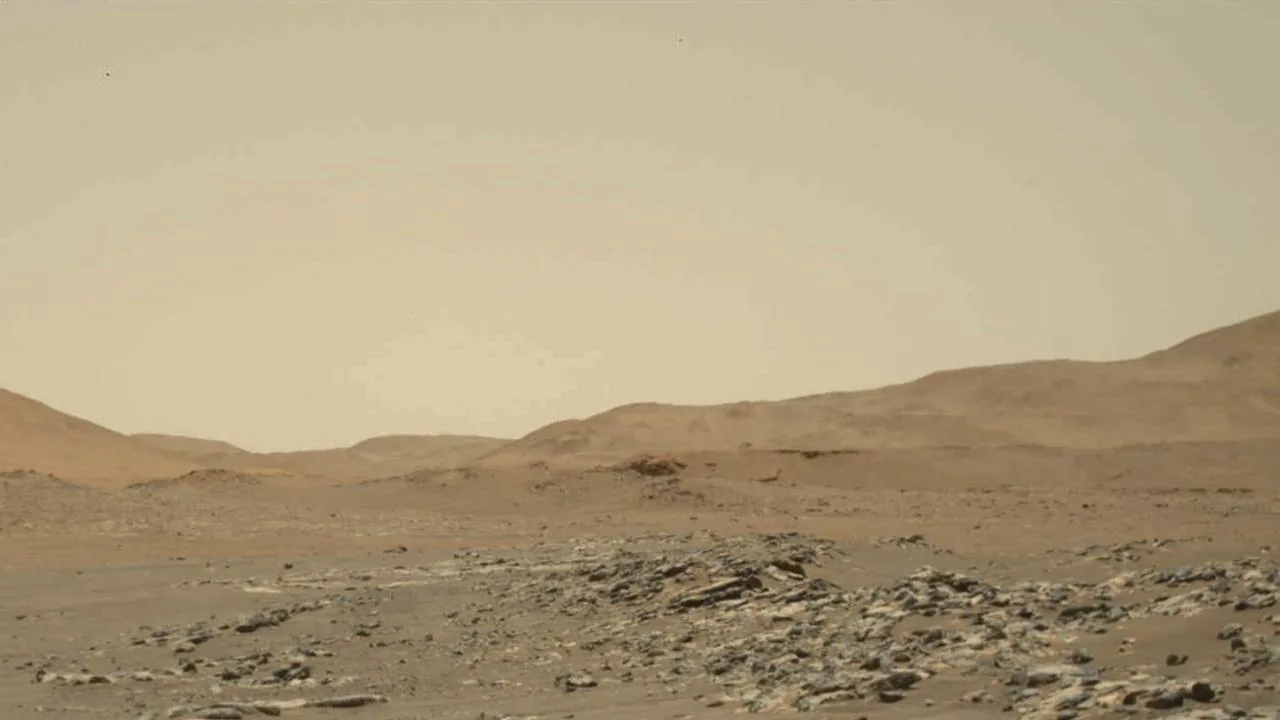 Ingenuity helicopter in flight above the rust-red Martian terrain