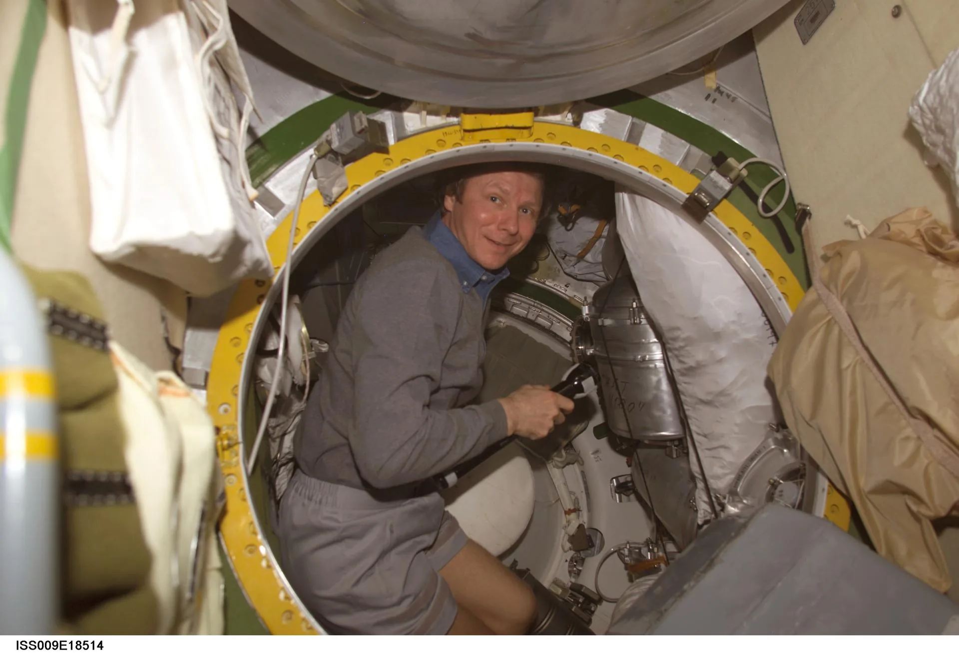 A cosmonaut inspects hatch seals inside the Russian segment Transfer Chamber on the International Space Station — the same area where structural cracks were later identified