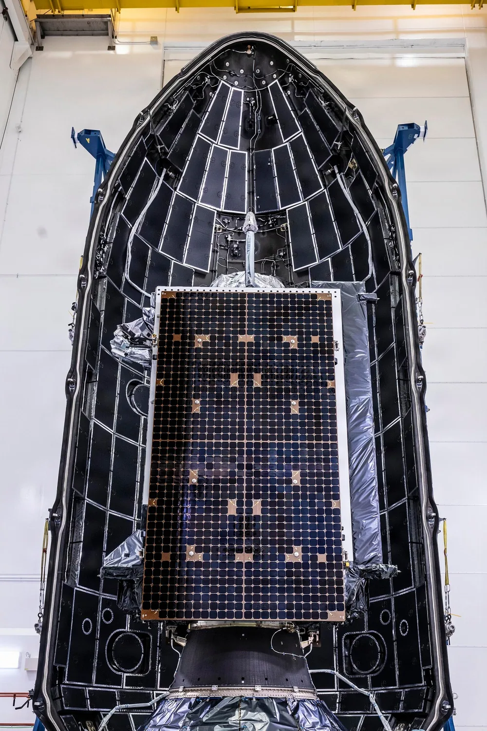 A Lockheed Martin GPS III satellite is encapsulated into the fairing of a SpaceX Falcon 9 in preparation for the GPS III-8 mission, the final GPS III to fly