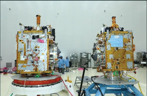 The two SpaDeX (Space Docking Experiment) twin satellites, assembled and tested by Ananth Technologies for ISRO, standing side-by-side on integration stands.