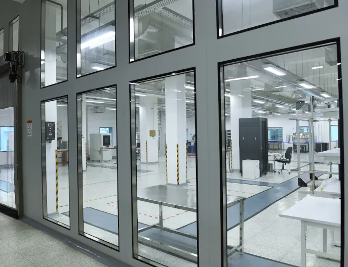 Azista BST Aerospace's controlled-environment satellite-integration cleanroom, viewed through a glass partition.