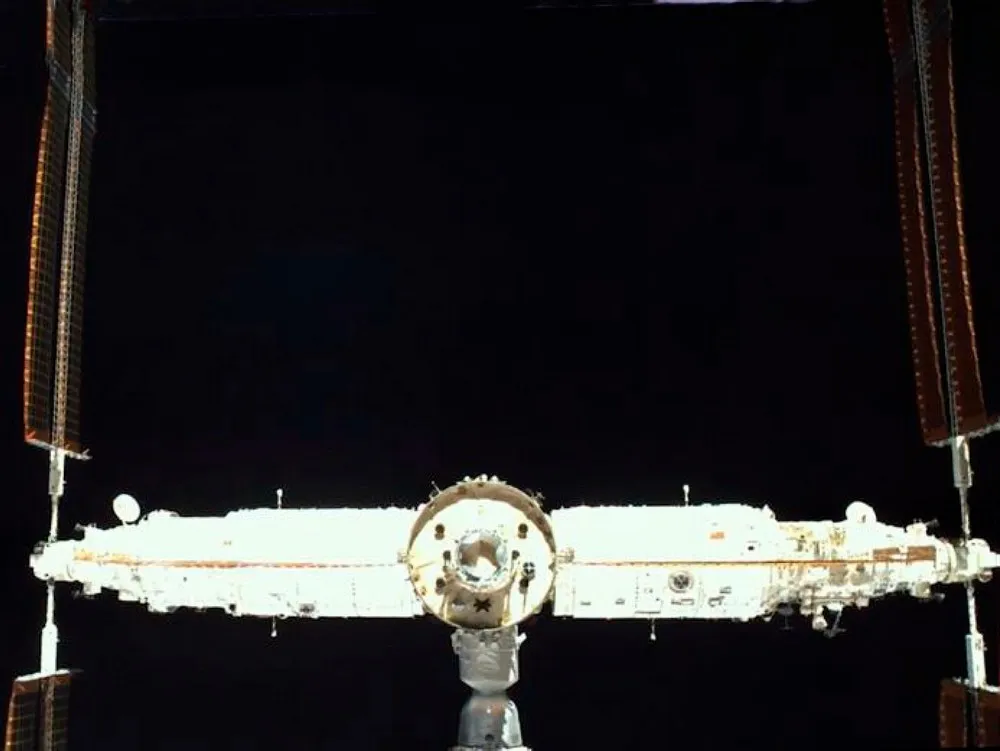 Rear view of China's Tiangong space station on orbit with a Shenzhou crew spacecraft docked — CAST builds the station's pressurised modules and the Shenzhou capsules.