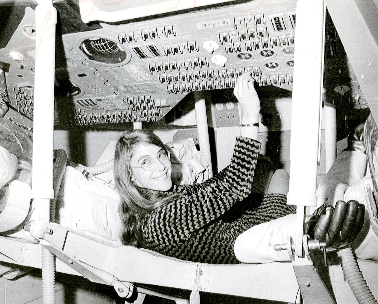 Margaret Hamilton, lead Apollo flight-software engineer at the MIT Instrumentation Laboratory (now Draper), beside the stack of Apollo Guidance Computer source-code listings her team produced.