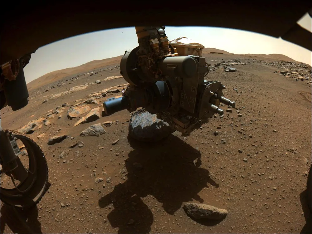 Perseverance's robotic-arm turret — carrying the Honeybee-built coring drill — positioned over the 'Rochette' rock on Mars.