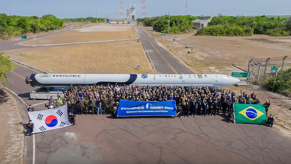 The HANBIT-Nano launch vehicle lies horizontal at the Alcântara Launch Center, Brazil, with Innospace, Brazilian Air Force and Brazilian Space Agency personnel ahead of its December 2025 flight.