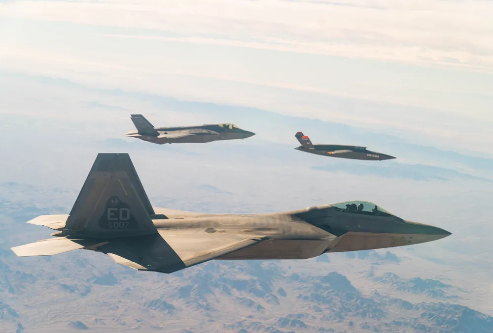 A U.S. Air Force F-22 and F-35 fly in formation with a Kratos XQ-58A Valkyrie.