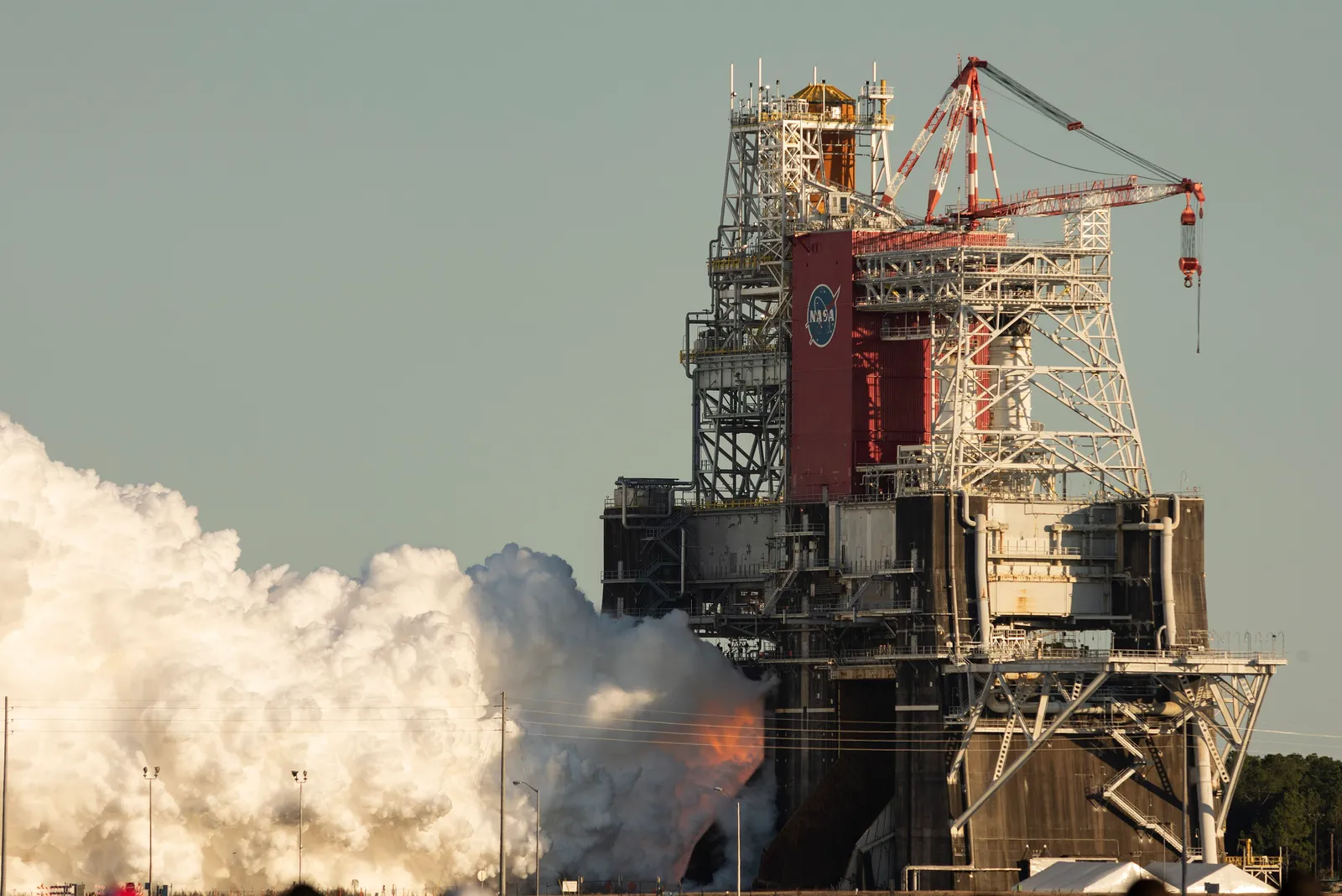 The four RS-25 engines of NASA's SLS core stage fire during a Green Run hot-fire test — L3Harris (Aerojet Rocketdyne) builds the RS-25.