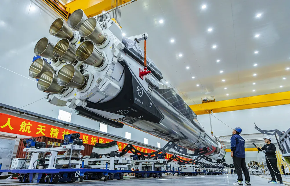LandSpace's stainless-steel Zhuque-3 first stage horizontal in the Jiuquan integration hall, exposing its cluster of nine Tianque methalox engine nozzles.