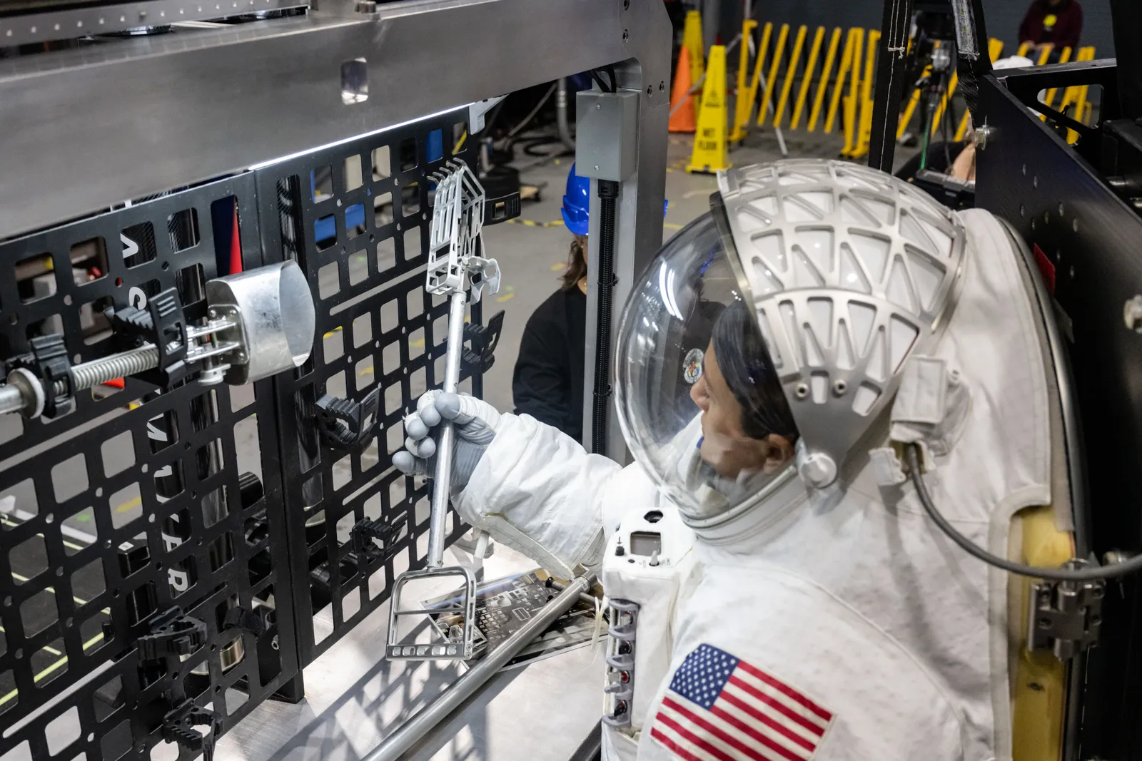NASA astronaut Jessica Meir retrieves a geology tool from Lunar Outpost's Eagle lunar terrain vehicle during human-in-the-loop testing at NASA's Johnson Space Center, October 2024.