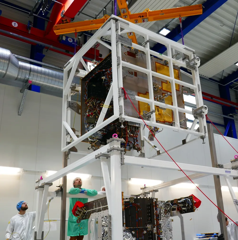 Hera's Core Module is lowered by crane onto its Propulsion Module during integration in the OHB cleanroom in Bremen in 2023.