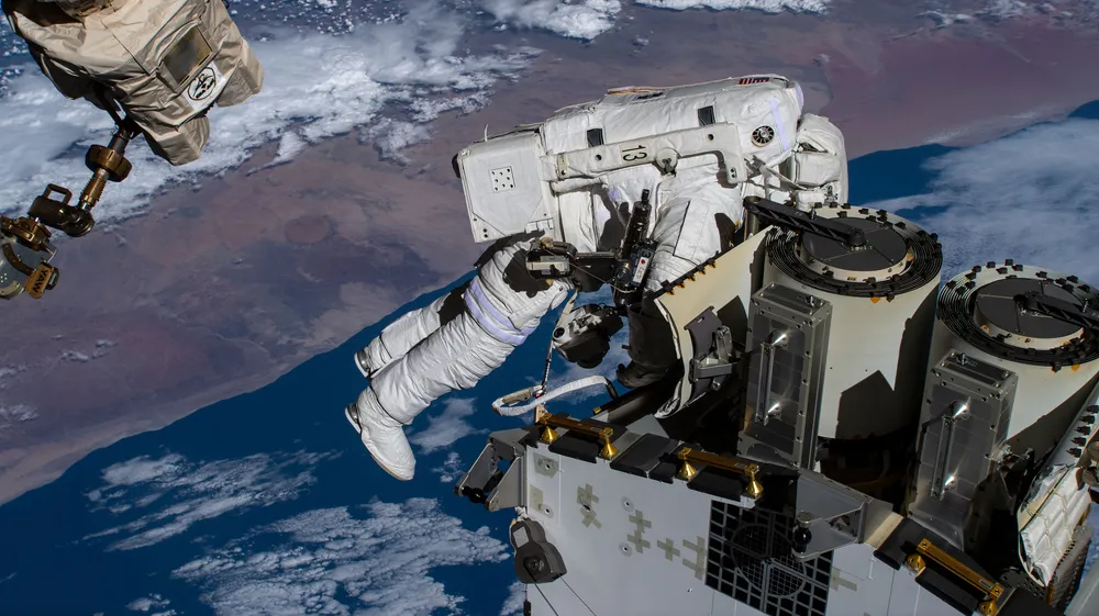 NASA astronaut Josh Cassada prepares a Redwire roll-out solar array for deployment during a spacewalk.