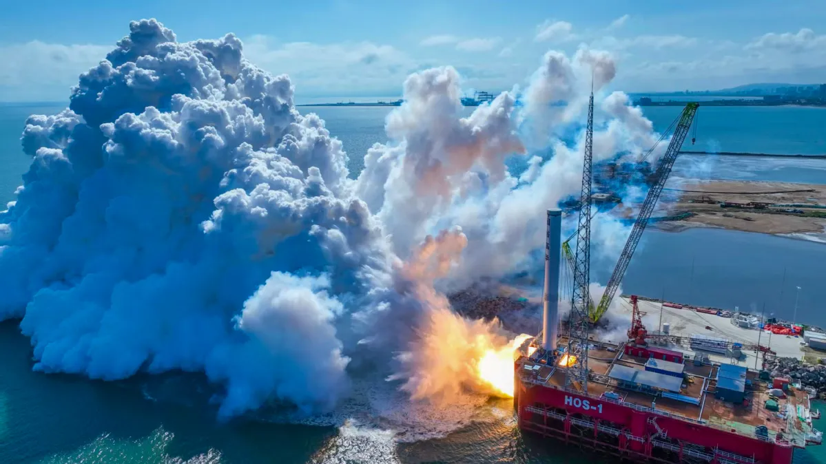 An aerial view of Space Pioneer's Tianlong-3 first-stage propulsion system static-fire test — its nine TH-12 kerolox engines firing on a coastal platform at Haiyang, Shandong, 15 September 2025.