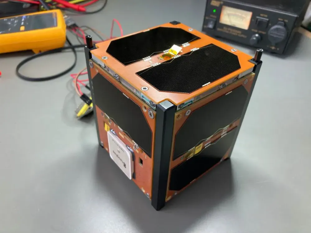 The GRBAlpha 1U CubeSat flight unit on a lab bench during integration — the first 1U CubeSat to detect a gamma-ray burst; Spacemanic supplied its platform, solar panels, on-board computer and GNSS receiver.