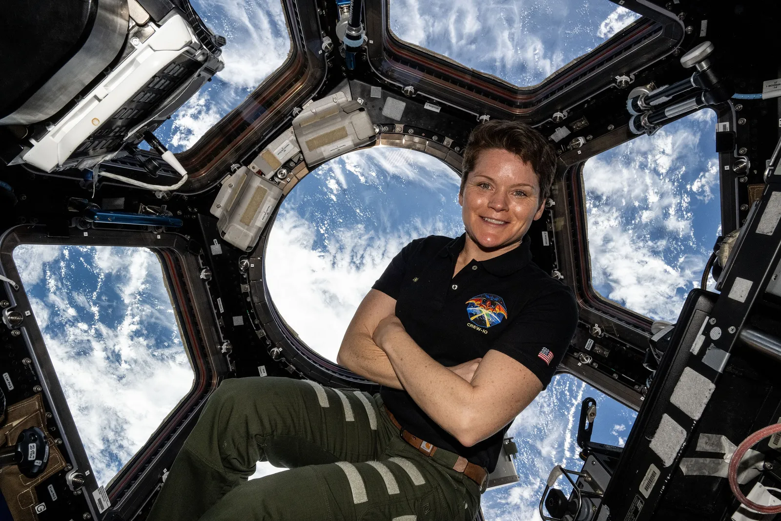 An astronaut framed by the seven windows of the ISS Cupola observation module, which was designed and built by Thales Alenia Space in Turin, Italy.