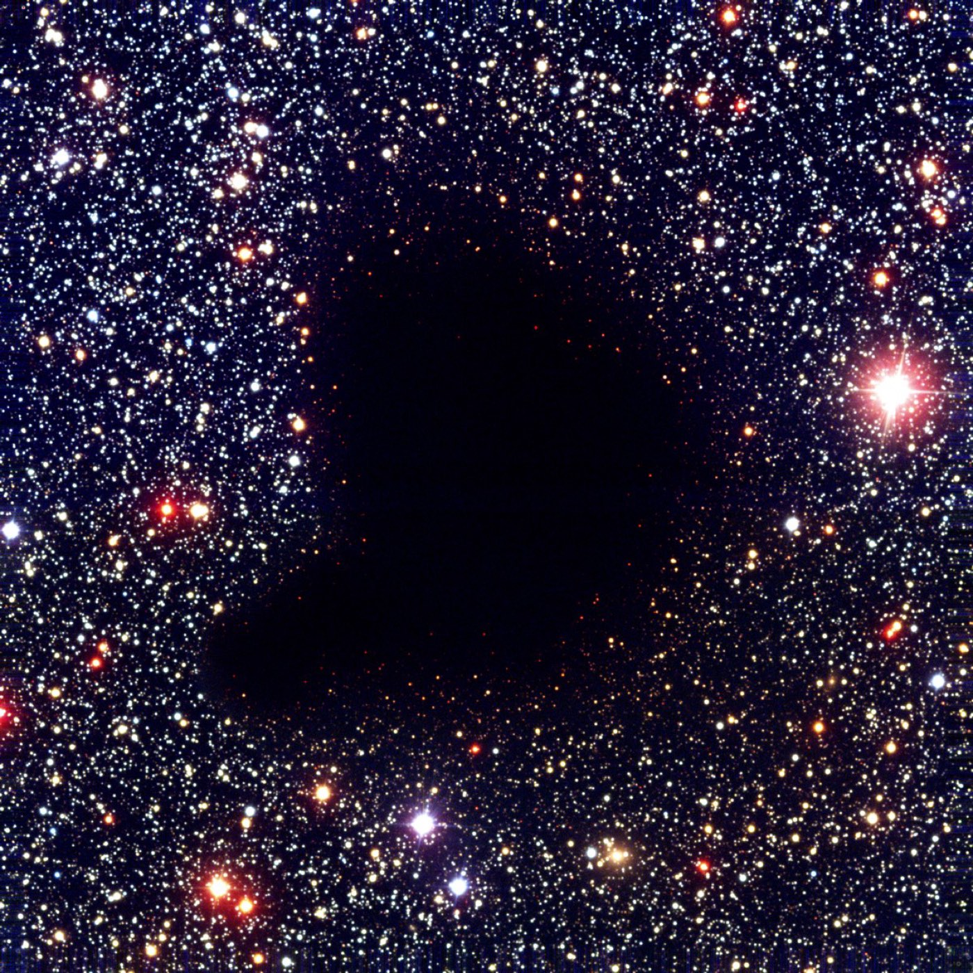 Barnard 68, a dark molecular cloud blotting out the dense starfield behind it.
