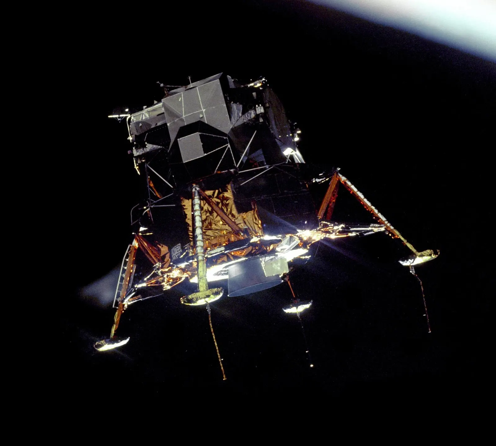 The lunar module Eagle in lunar orbit, Earth behind it, seen from Columbia