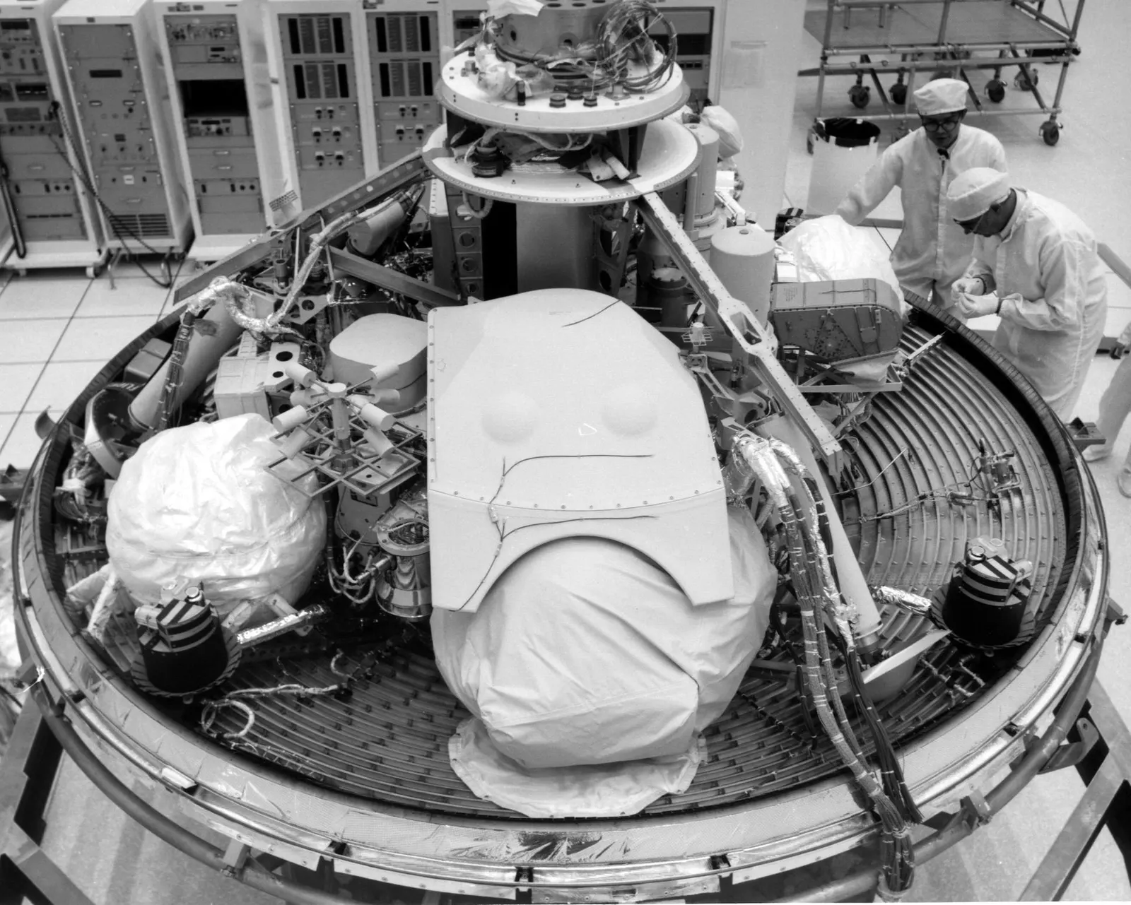 Technicians inspect a Viking lander in a Kennedy Space Center cleanroom during pre-launch integration, 1975