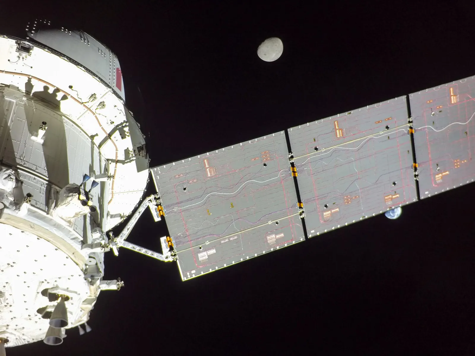 Flight Day 14 — Orion's solar array wing divides Earth and the Moon