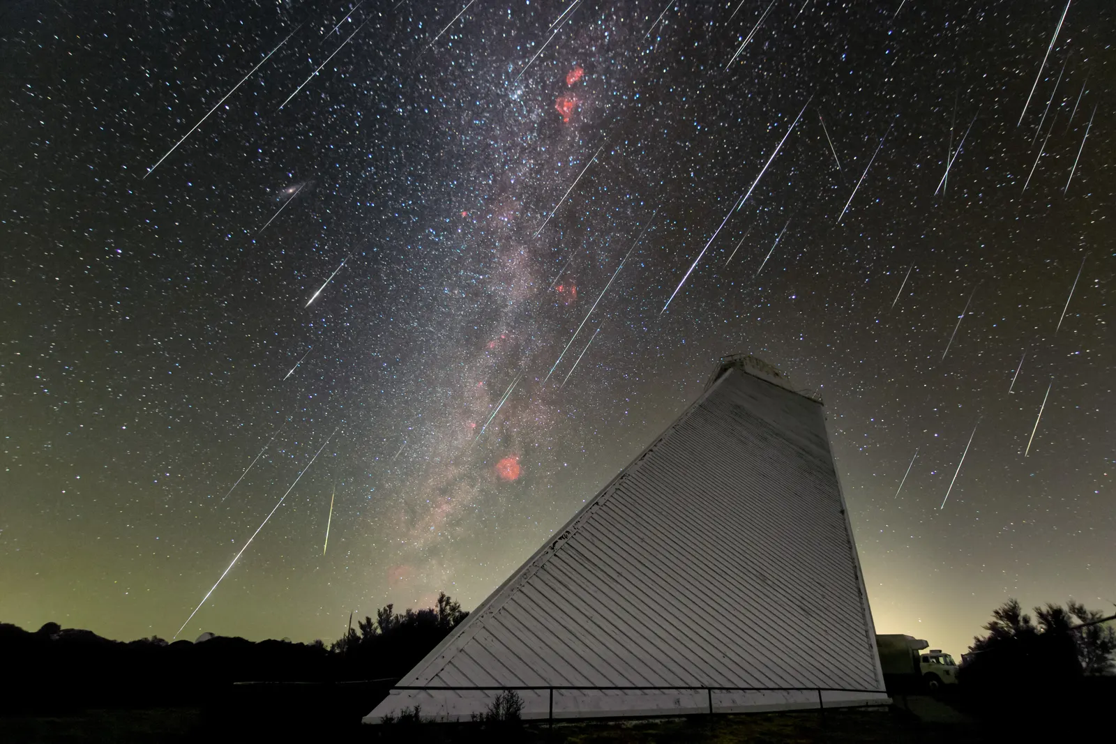 Composite long-exposure image showing multiple Geminid meteor streaks cascading from the radiant in Gemini above Kitt Peak