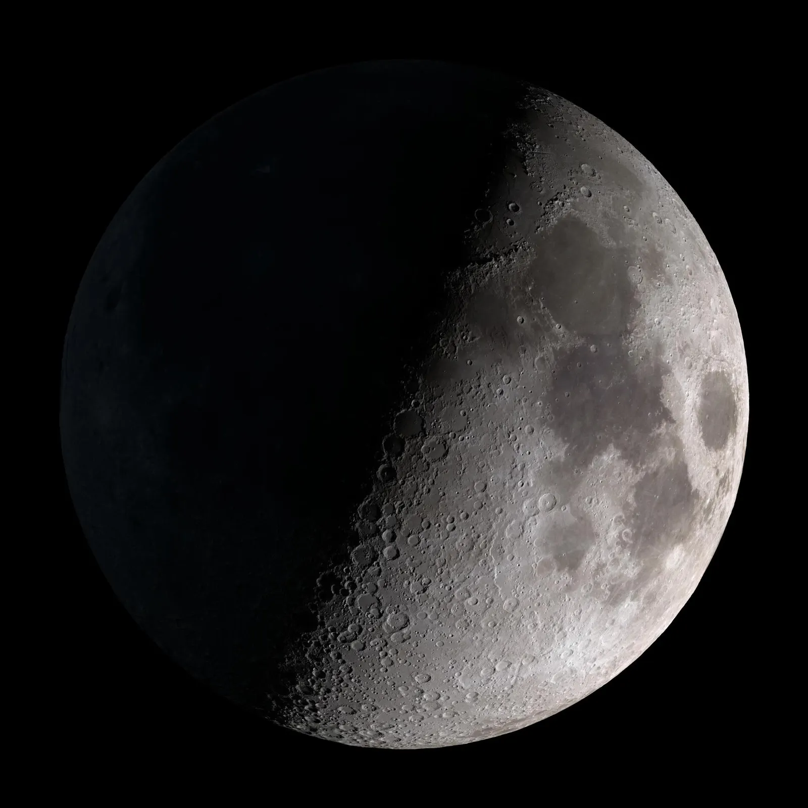 First Quarter Moon with dramatic shadows along the terminator revealing crater walls and lunar mountains