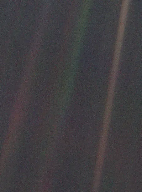 Earth as a tiny pale blue dot in a sunbeam, photographed by Voyager 1 from 4 billion miles away in 1990