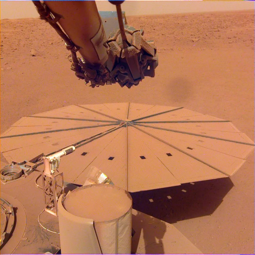 Dust-covered circular solar panel of the InSight lander on the reddish Martian surface