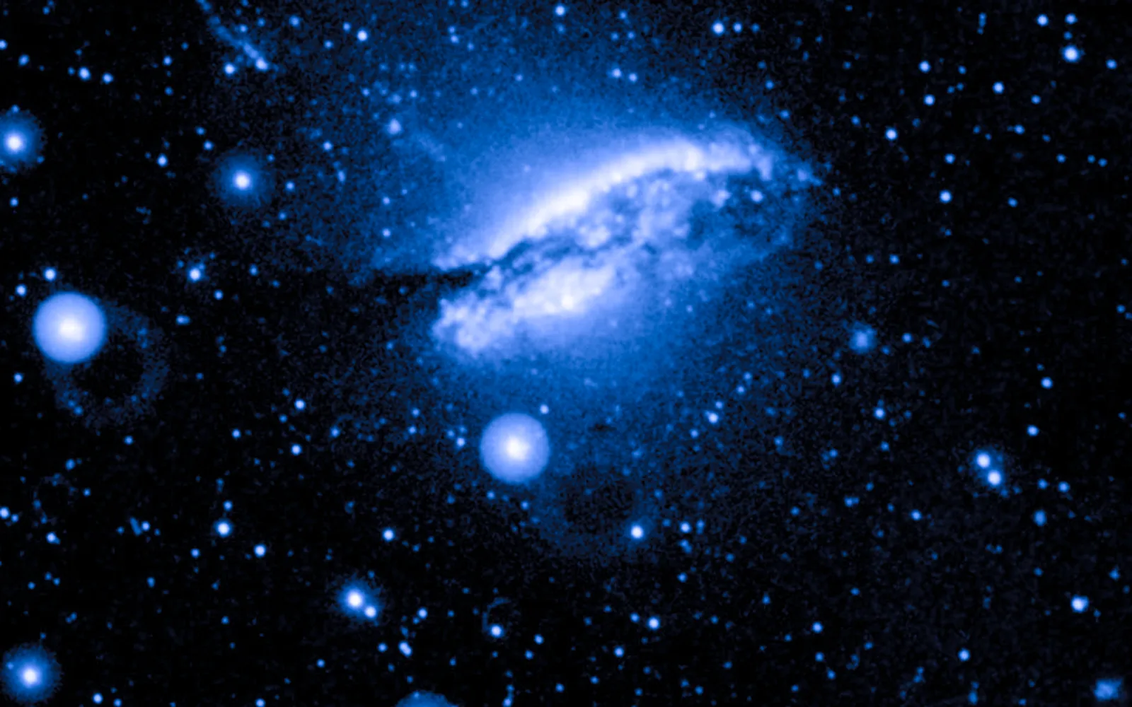 Centaurus A in ultraviolet — GALEX's ultraviolet eye picks out hot young stars — including bursts of star formation strung along the path of the black hole's jet, beyond the galaxy's main body.