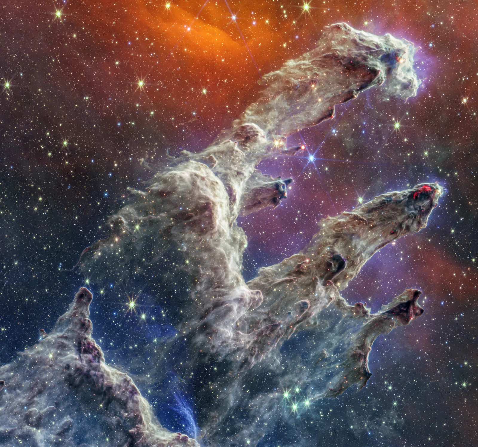 Eagle Nebula in infrared — JWST NIRCam pierces the pillar dust to reveal embedded protostars and jets in unprecedented detail, confirming active star formation hidden from optical view for decades.