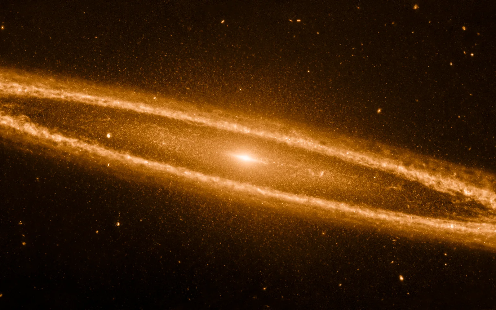 M104 (Sombrero Galaxy) in infrared — JWST's mid-infrared view dissolves the Sombrero's bright bulge and reveals a smooth inner disk wrapped in a clumpy outer ring of dust — knots where carbon-rich molecules trace pockets of star formation.