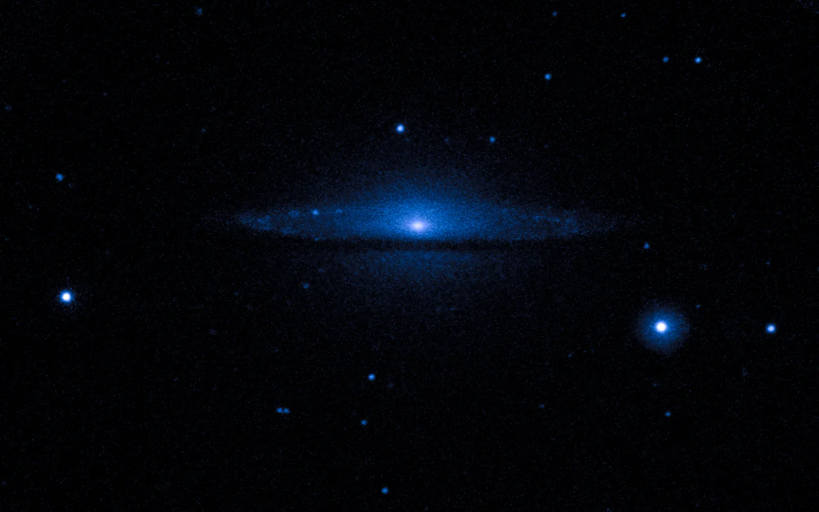 M104 (Sombrero Galaxy) in ultraviolet — In ultraviolet the Sombrero is faint and smooth — a quiet, ageing galaxy with little ongoing star formation, its glow dominated by the diffuse light of its old stellar population.