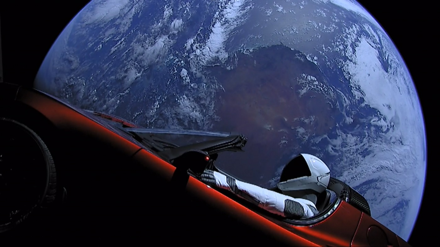 "Starman" in SpaceX's Tesla Roadster with Earth behind, from the Falcon Heavy demo flight in February 2018 (SpaceX, public domain)